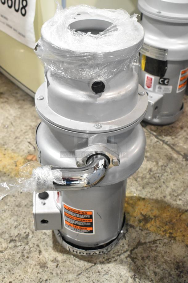 Brand new Hobart FD4/125-3 commercial disposer, 1 1/4 hp, 120/208-240V. Scratch and dent, with warning labels visible.