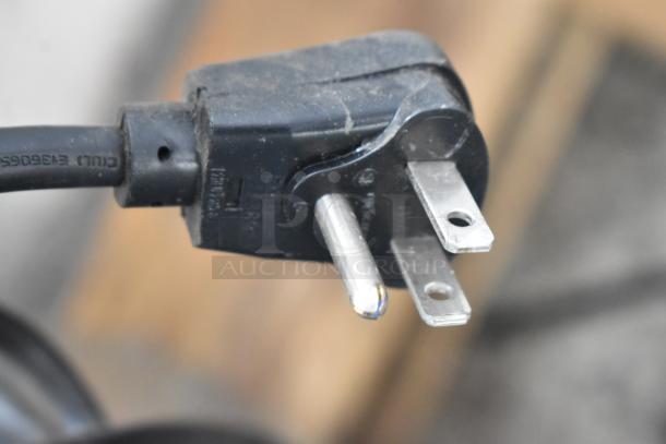 Close-up image of a three-prong power plug showing details of prongs and black casing.