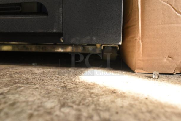 Brand new Avantco 189BVAC28HC 28" black refrigerated air curtain merchandiser on casters; visible scratch and dent.
