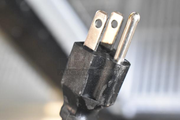 Close-up of a power plug for a 2024 Avantco 178GDS47HCB refrigerator, showing standard three-prong design.