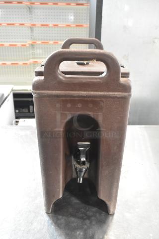 Brand new Cambro brown poly beverage dispenser with handles and spout, minor scratches and dents visible.