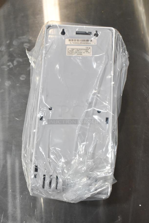 Brand new Cambro white poly wall mount hand sanitizer dispenser in packaging, visible label states liquid output capacity and voltage.