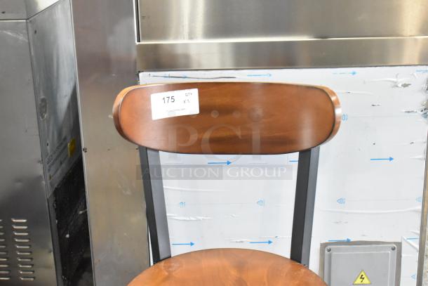 Brand new Cambro metal dining chair with wooden backrest and seat, scratch and dent condition. Label reads "175 QTY XL".