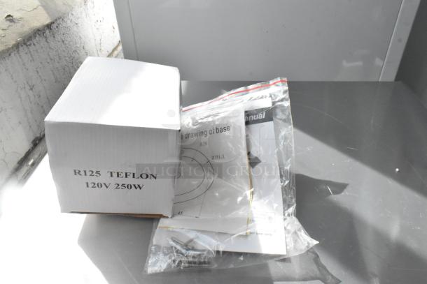 BRAND NEW Cambro CK2502B004 Gold Warming Lamp, 115V, 1 Phase, shown with manual and electrical components.