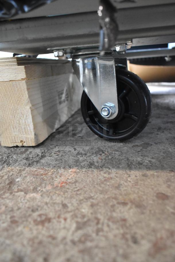 Mainstreet 829BMR49F freezer caster wheel, mounted on wooden block, detail of stainless steel frame and poly-coated wheel.
