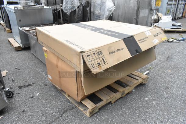 Fisher & Paykel refrigerator door panel in box marked "SCRATCH AND DENT." Box on pallet, SKU 346854 and SKSPK480FM visible.