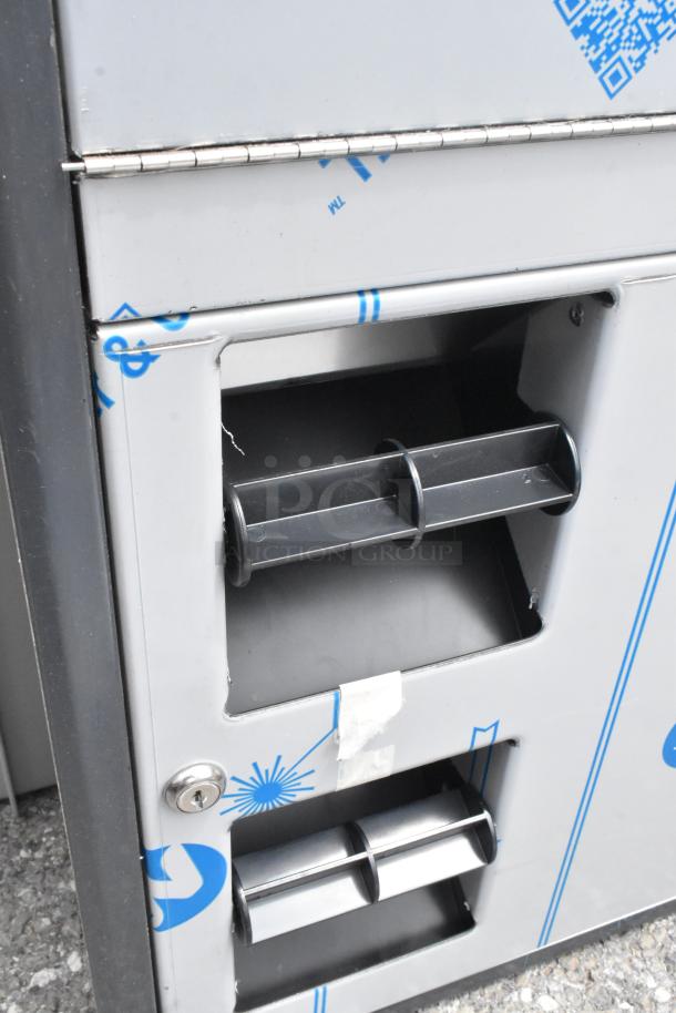 Brand new stainless steel toilet paper dispenser, slight scratch and dent condition, features dual roll holders and locking mechanism.