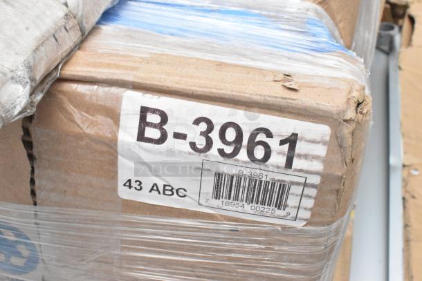 Box with "B-3961" label, containing Regency stainless steel items. Box shows wear; contents include scratch and dent shelves.