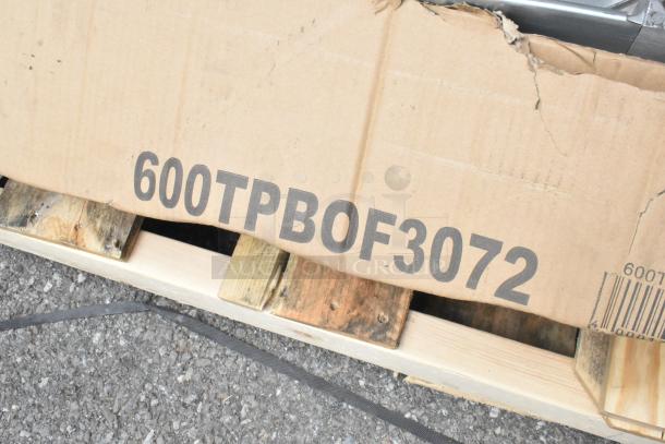 Cardboard box labeled "600TPBOF3072" on a pallet, showing scratch and dent condition. Contains Regency stainless steel items.