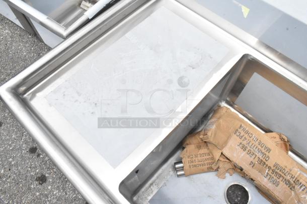 BRAND NEW Regency 600S12424218 stainless steel single bay sink with dual drain boards, minor scratches, boxed parts included.