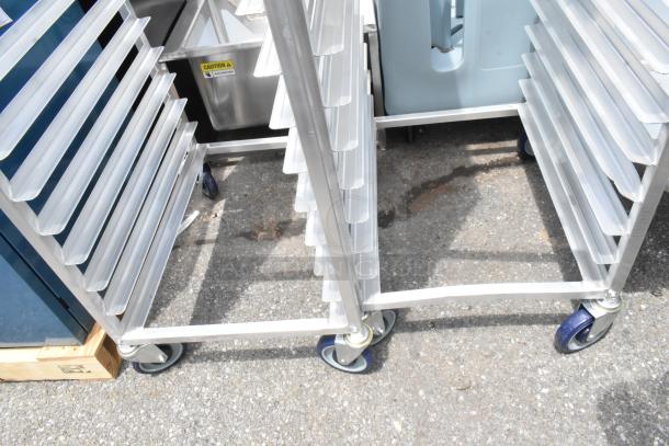 2 new Advance Tabco PR20-3W 20 pan end load racks with scratch and dent; commercial casters; outdoors on pavement.