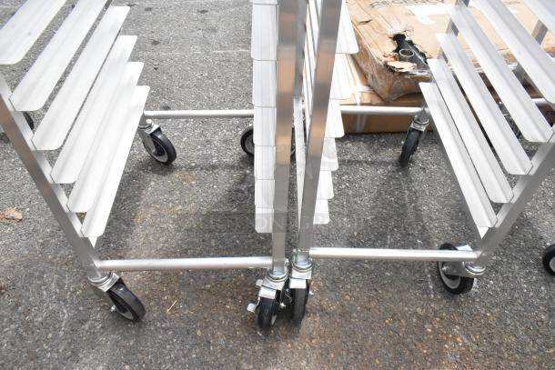 2 new Regency 600STPR20KD 20 pan aluminum steam table pan racks on commercial casters, slightly scratched, ready for use.