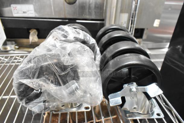 Lot of 8 black commercial casters, brand new with some scratches, partially wrapped in plastic.