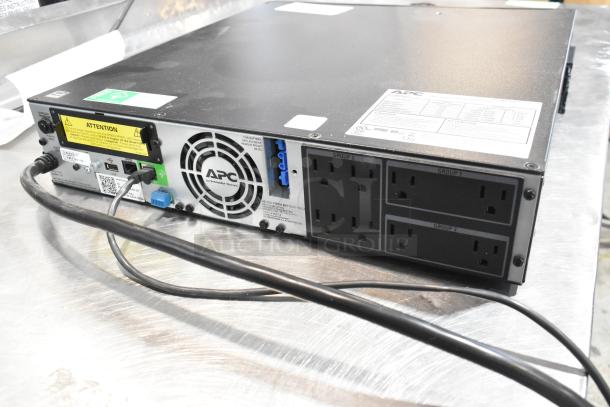 APC Uninterruptible Power Supply, shown with rear ports and labels, in good condition. Features multiple outlets and APC branding.