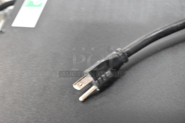 Close-up of an APC uninterruptible power supply plug on a black surface.