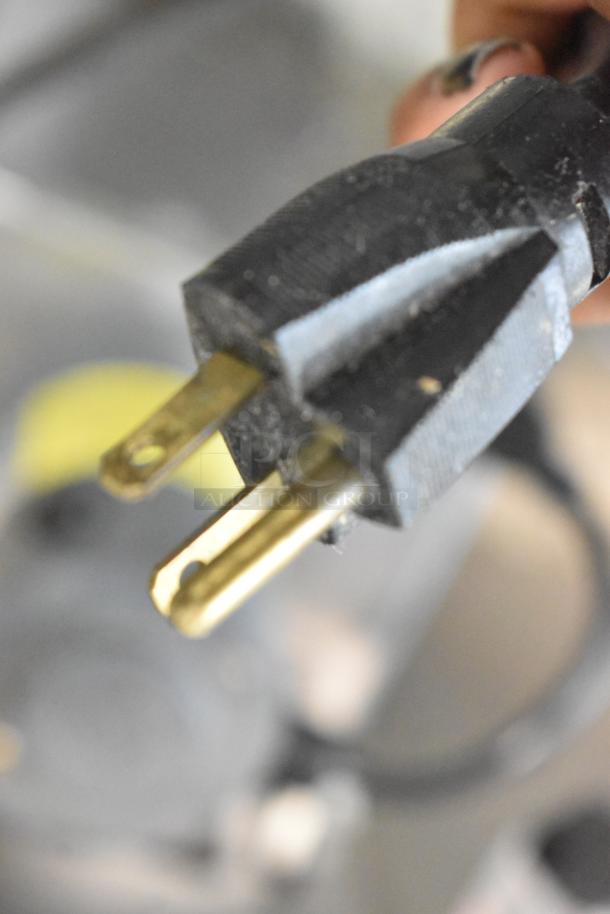 Close-up of the plug for a Stoelting SF121-38I2 soft serve machine, showing a standard three-prong design.