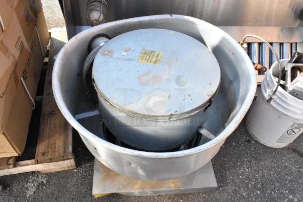Metal commercial mushroom exhaust hood with visible wear, label displaying maintenance info, surrounded by packaging.