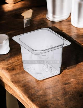 Cambro 65CLRCW135 Camwear® 1/6 size clear polycarbonate colander pan, 4" deep, great condition, on wooden surface.
