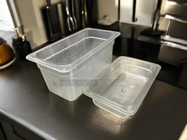 Cambro clear food storage containers, sizes 1/3" and 1/4", in excellent condition, displayed on a kitchen counter.