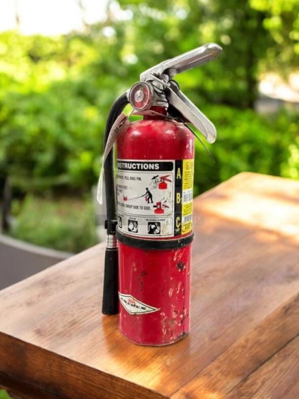 AMEREX Model A500 dry chemical fire extinguisher in red. Shows signs of use. Visible instructions label.