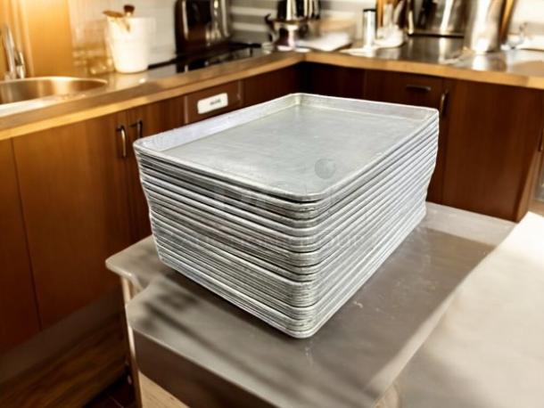 Stack of half-size bakery sheet pans, 13x18x1", in excellent condition. Made of metal, ideal for baking or roasting.