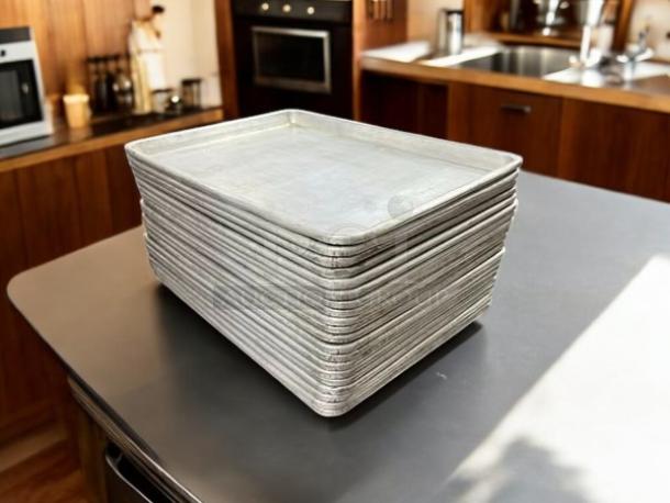 Stack of excellent condition half size bakery sheet pans, 13x18x1 inches, shown on kitchen counter.
