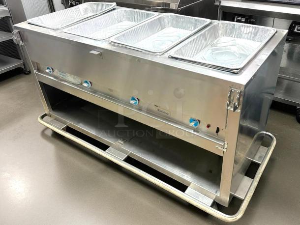 Stainless steel commercial food warmer with four aluminum trays, temperature controls, and durable frame. Good condition.