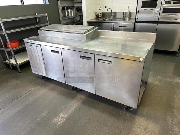 Delfield 91in 3-door refrigerated pizza prep table on casters in great condition. Tested and working, model 000-20191PTC.