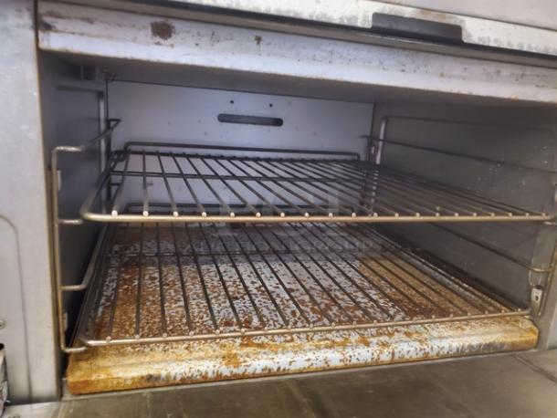 Patriot FMGR-36/NG 6 Burner Range with standard oven base, on casters. Natural gas, 210,000 BTU. Missing 3 knobs. Interior rust visible.