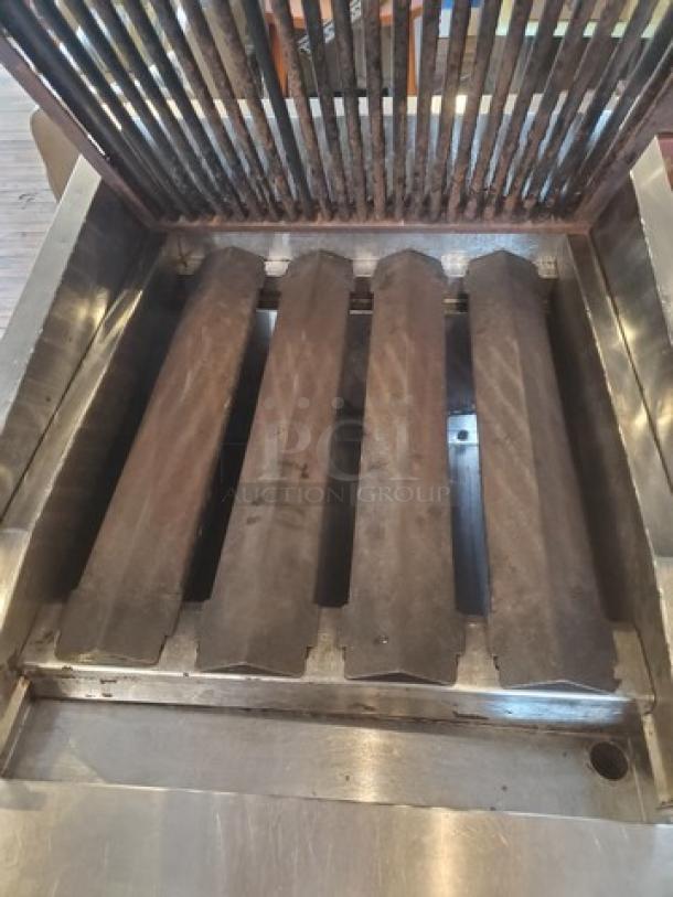 MagiKitch'n CM624 Charbroiler, stainless steel, visible grates, used condition, suitable for commercial cooking.