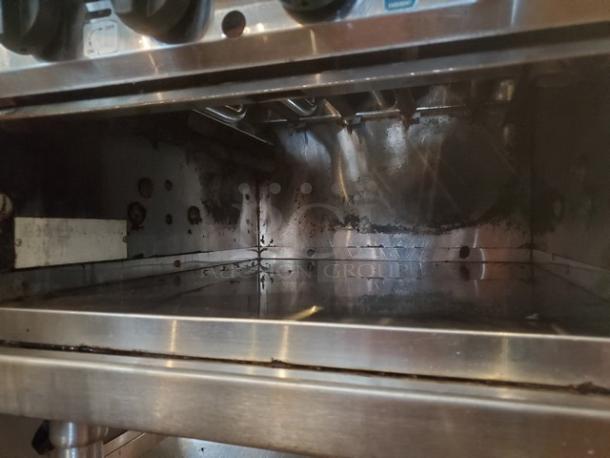 MagiKitch'n Model CM624 Charbroiler, stainless steel, interior view, showing grilling area and controls, used condition.
