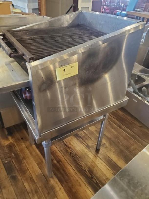MagiKitch'n Model CM624 Charbroiler, stainless steel, used condition, visible wear, mounted on metal stand, label indicates auction lot 5.