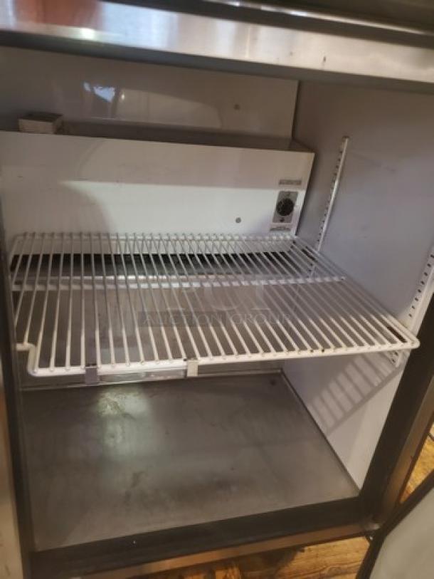 True TSSU-72-16 prep table interior with shelving shown. Needs caster replacement. Model: TSSU-72-16.