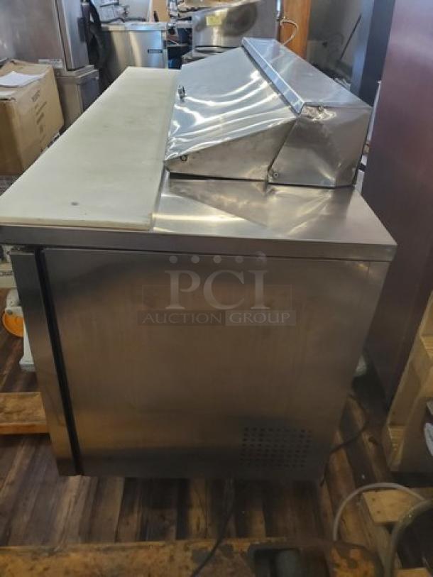 True TSSU-72-16 72" sandwich/salad prep table, stainless steel, 1/2 HP, 115V, shows wear, casters need replacing.