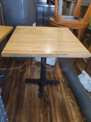 30x30 wood table top with sturdy black metal base, in good condition, ideal for cafes or restaurants.