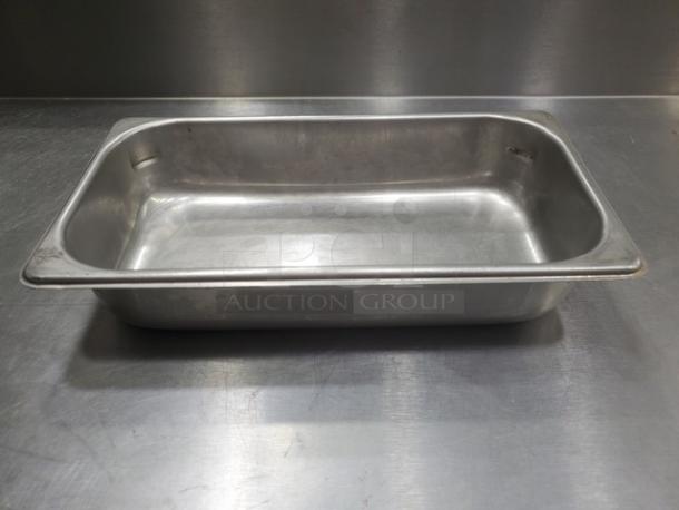 Lot of 4 stainless steel food pans, used condition, rectangular shape, suitable for commercial kitchen use.