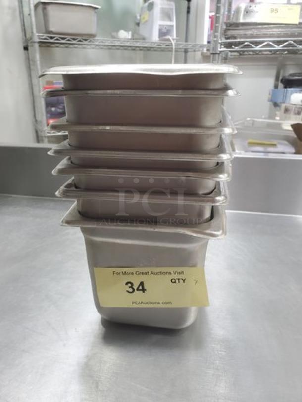 Lot of 7 stainless steel square food pans, 2.7 qts each, stacked. Good condition with auction label indicating quantity.
