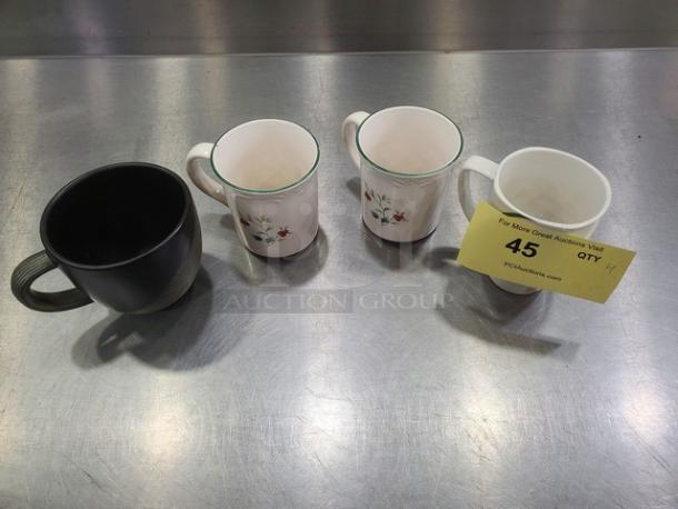 Lot of 4 mugs including one black textured mug and three white mugs with floral designs; slight wear visible. Quantity tag reads "45 QTY 4."