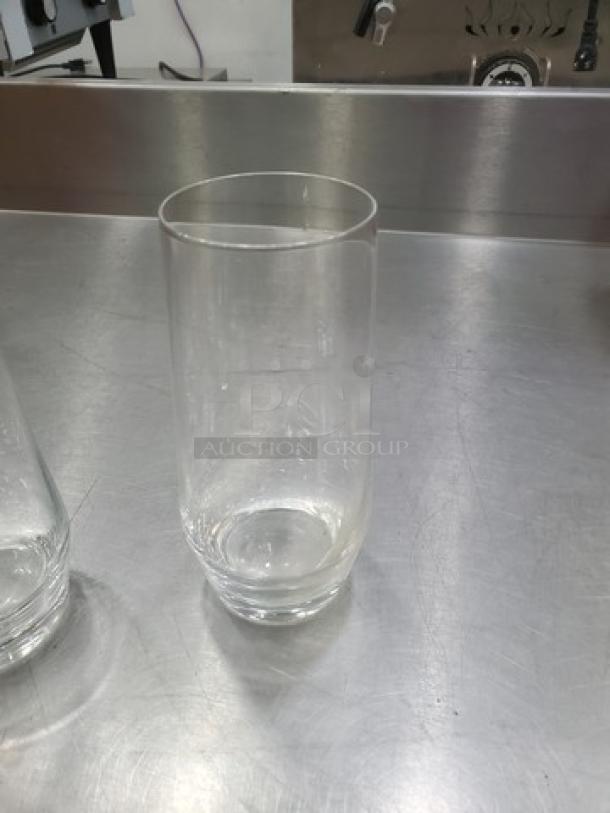 Set of 19 clear glass drinking glasses, cylindrical shape, good condition, smooth finish, appropriate for everyday use.