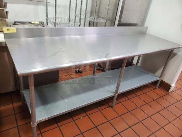 96" stainless steel work table with backsplash and lower shelf, excellent condition. Ideal for kitchen or industrial use.