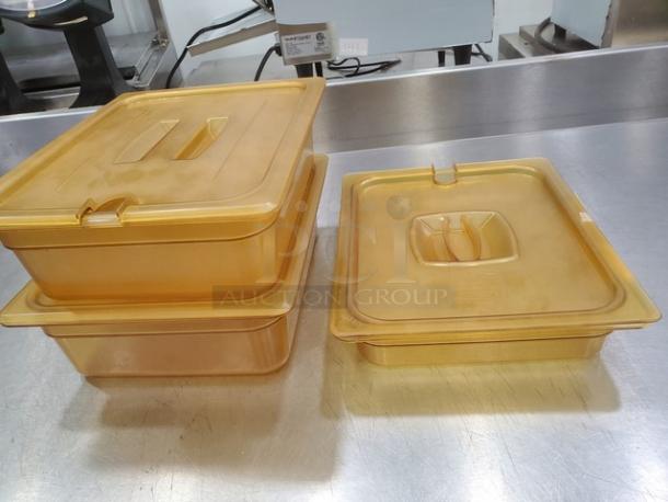 Lot of 3 yellow plastic food pans with lids, square shape, stackable design, used condition, visible wear marks.