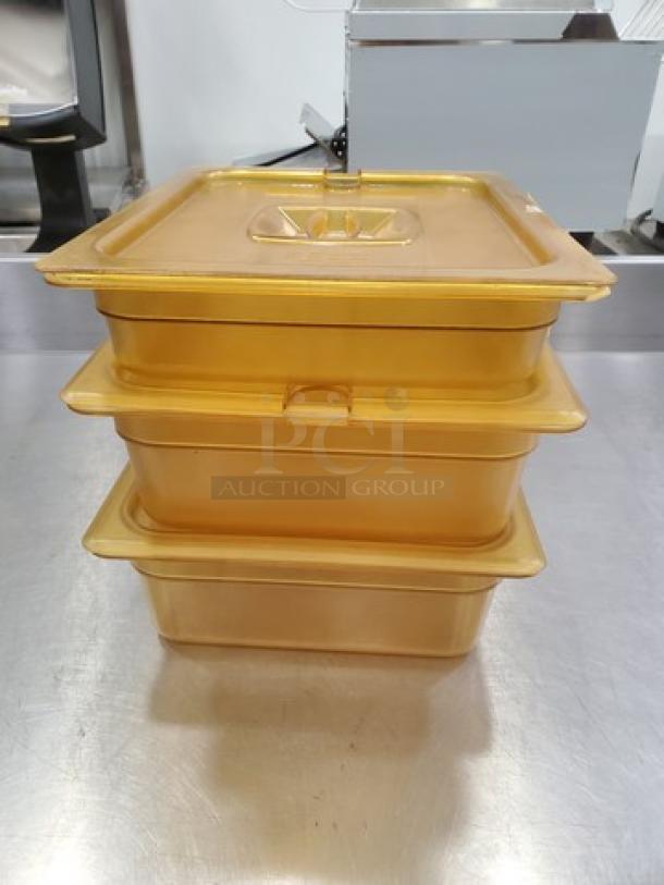 Set of 3 amber plastic food pans with lids, sturdy condition, ideal for commercial kitchen use, stackable design.