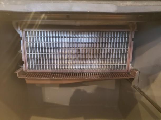 Ice-O-Matic ICEU220HA3 commercial undercounter ice maker interior, showing metal grid in used condition.