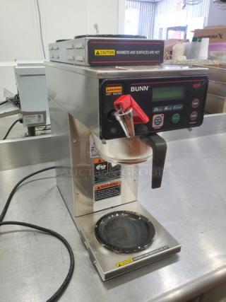 Bunn AXIOM DV-3 coffee brewer with two upper and one lower warmer, stainless steel body, digital display, warning labels visible.