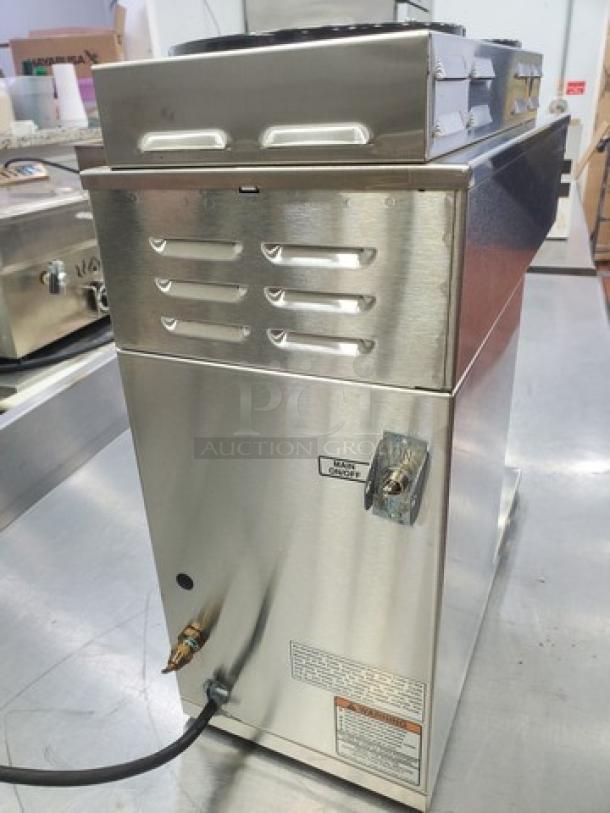 Bunn AXIOM DV-3 coffee brewer with dual volt, 2 upper, 1 lower warmer. Stainless steel, visible tags and labels, good condition.