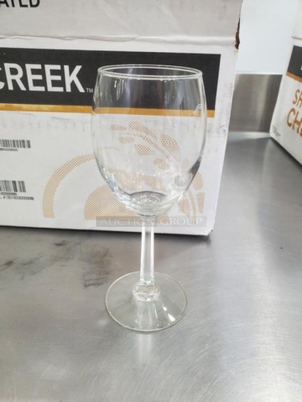 Clear glass wine goblet from a lot of 18, featuring a simple stem design. Appears in excellent condition.