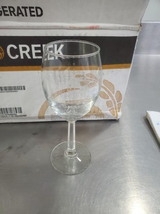 Clear glass wine glass from a lot of 14, in good condition. Marked with "Admiral's Choice." Simple, elegant design.