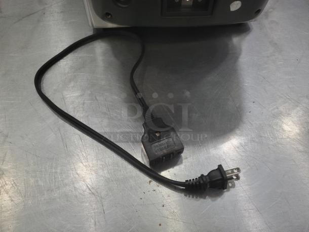 Farberware 103736 Countertop Fryer power cord detail on metal surface, showing cable and plug condition.