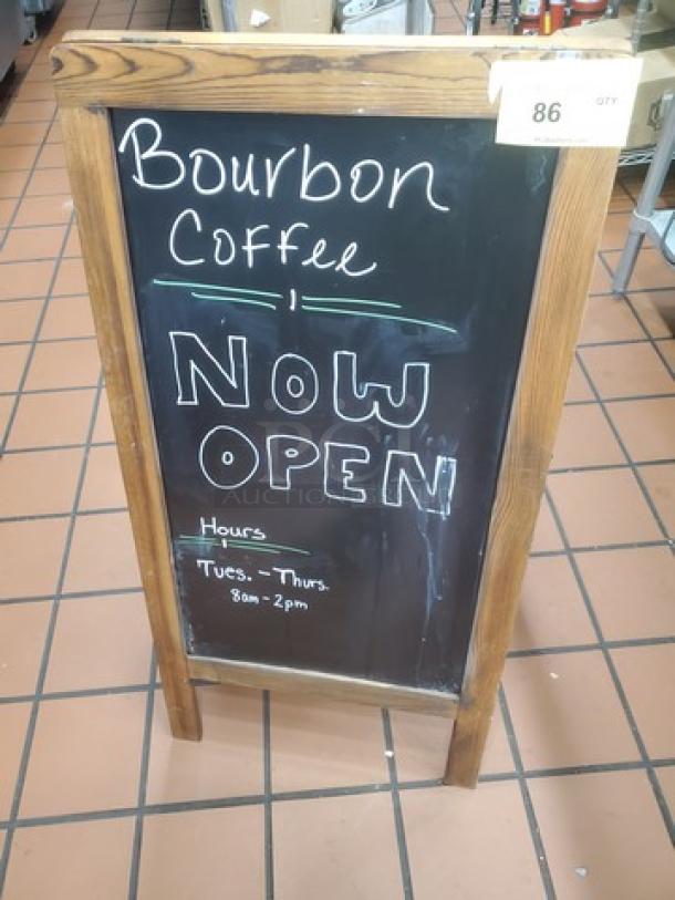 Wooden framed chalkboard sign for "Bourbon Coffee," marked "Now Open" with hours "Tues. - Thurs. 8am - 2pm."
