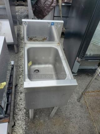 Stainless steel one compartment sink, commercial-grade, with backsplash. Visible mounting holes, good condition.